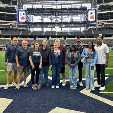 Sports Traveler Cowboys Weekend package guests on the field at AT&T Stadium