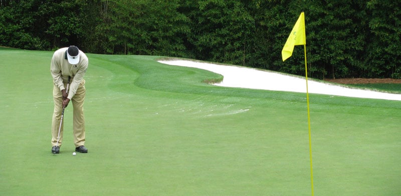 Player making a putt on the famous Augusta National Golf Course