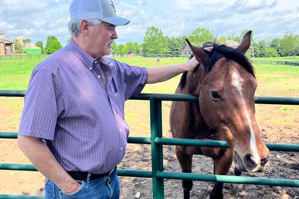 Guest interacting with a horse at Old Friends Farm