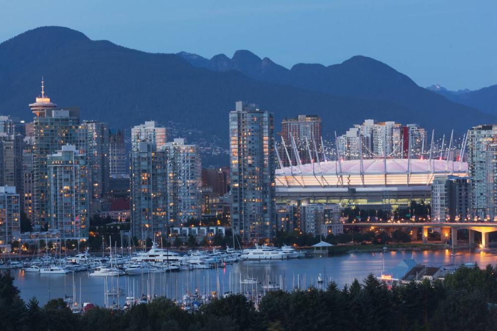 Vancouver city skyline at night, False Creek, Cambie Bridge, Harbour Centre, BC Place, mountains, boats