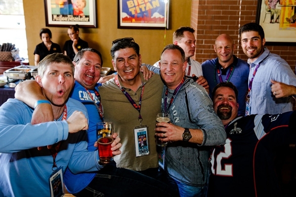 Fans enjoying drinks and cheering at a tailgate party